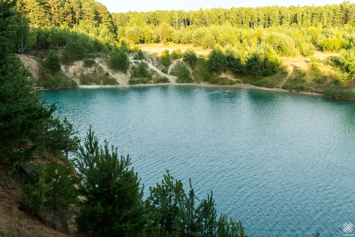Бирюзовая вода карьера у подножия склона